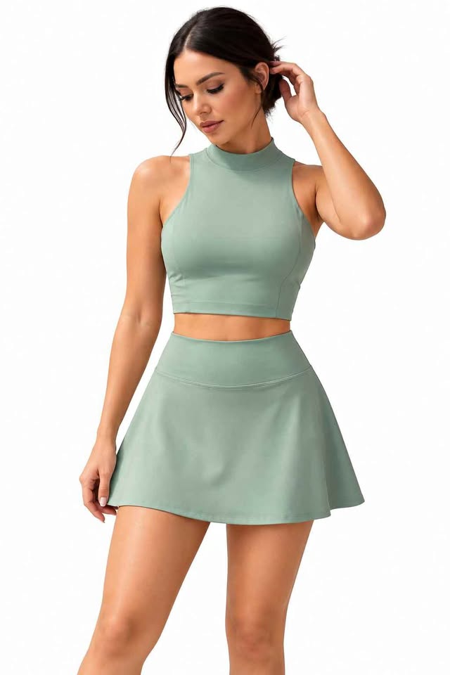 Model wearing a sage sleeveless top and pleated skirt